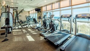 Gimnasio con cintas de correr, elípticas y equipo de pesas.