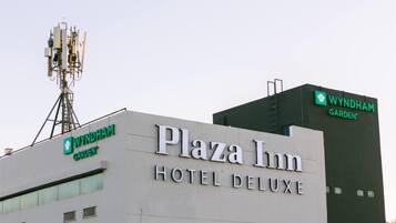 Exterior del Hotel Plaza Inn Deluxe con un cartel visible de Wyndham Garden.
