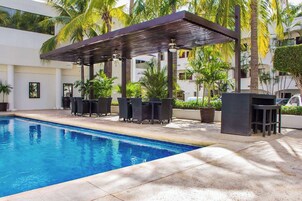 Una piscina al aire libre, sillones reclinables de piscina