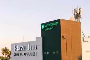 El exterior del Hotel Plaza Inn Deluxe con un letrero Wyndham Garden en la parte superior.