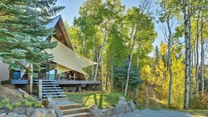 A modern cabin with a sloped roof, surrounded by a forest. - Irwin A-Frame Cabin w/ Deck & Mountain Views! (Irwin)