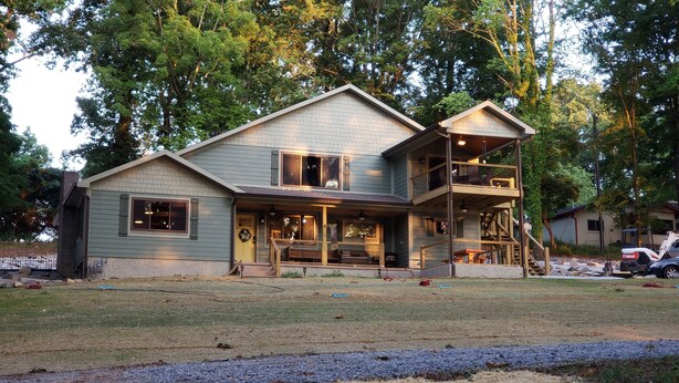 A two-story house with a front porch, a covered deck, and a garage.