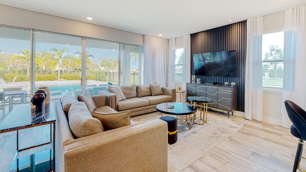 A modern living room with a sofa, coffee table, and TV. - Rock 'n' Roll Villa with Splash Pad at Encore (Kissimmee)