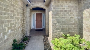 A stone-walled building with a wooden door and a small pathway leading to it. - It's a Fantasea-78 TP (Laguna Vista)