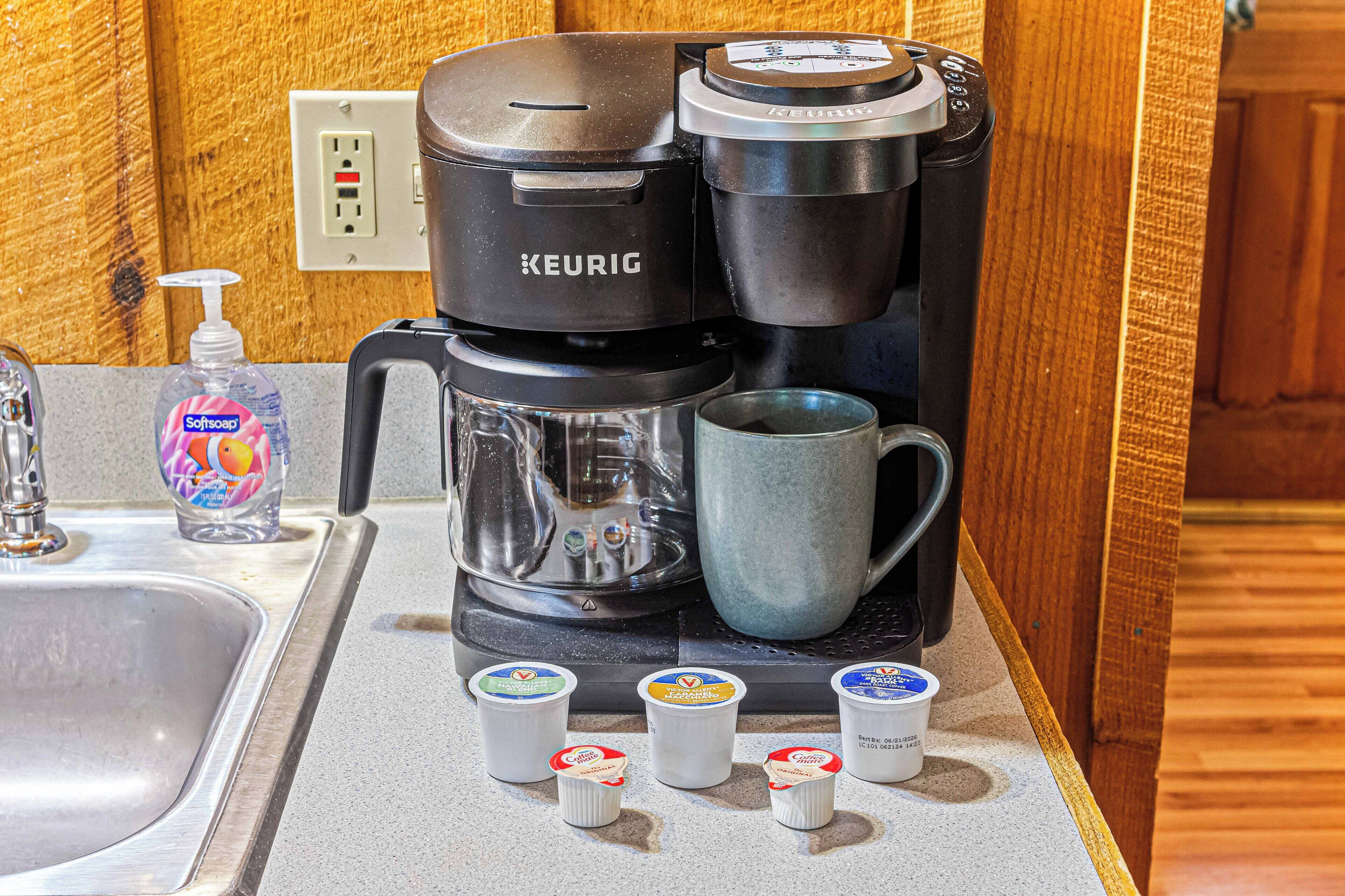 A Keurig coffee maker with four coffee pods on a kitchen counter.