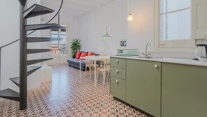 Une cuisine moderne avec un escalier en colimaçon, un coin repas avec un canapé et une grande fenêtre.