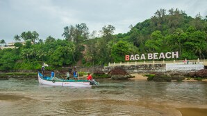 A boat on a river with a sign reading "Baga Beach" in the background. - Baga Beach Myron (Baga)