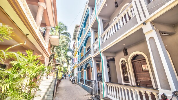 A narrow street with multi-story buildings, balconies, and a 'No Smoking' sign. - Baga Beach Myron (Baga)