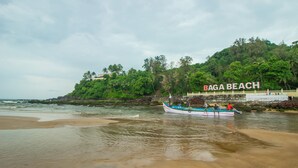 A boat on a beach with a sign reading "Baga Beach" in the background. - Baga Beach Myron (Baga)