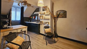 Une cuisine de taille réduite comprenant un coin repas, un luminaire suspendu et un élément de décoration rustique.