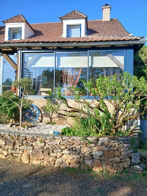 A house with a stone wall, a blue wheel, and a window.