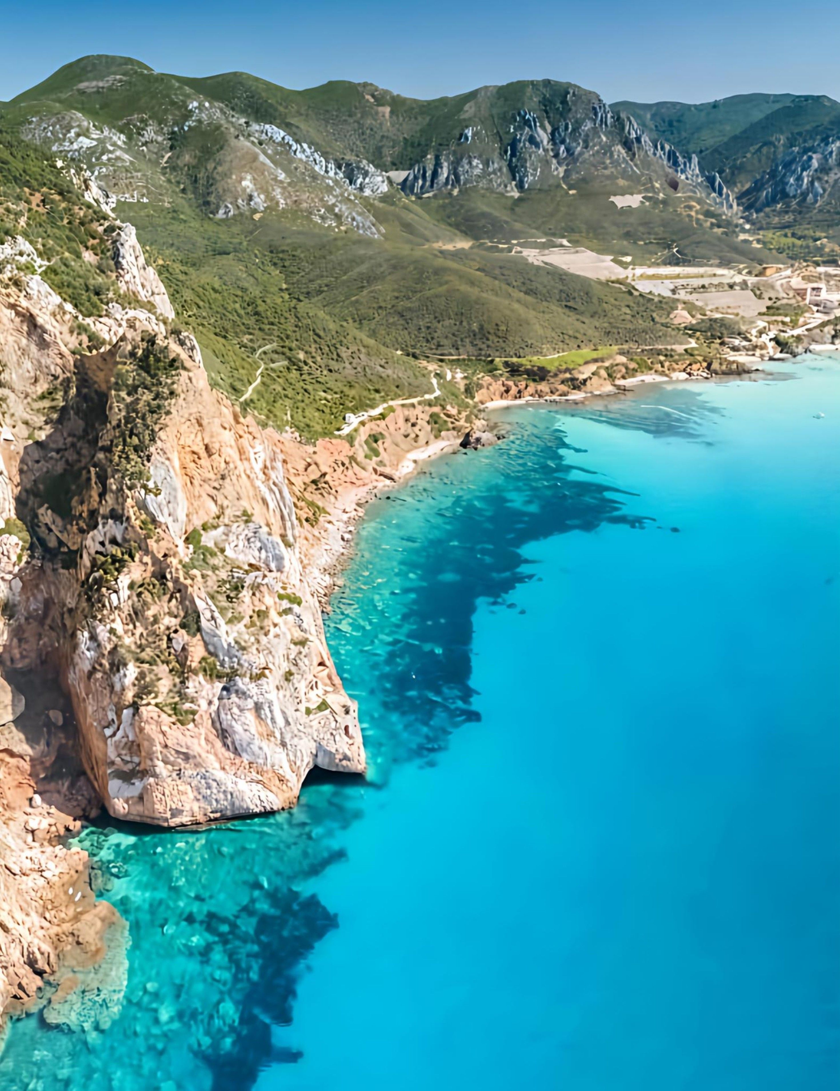 Un paysage côtier caractérisé par des eaux turquoise limpides, des falaises rocheuses et un relief montagneux.