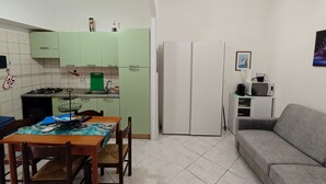 A compact living space with a dining area, kitchenette, sofa, and a refrigerator. - Holiday Home "Casa Barbara" with Air Conditioning and WiFi (Nebida)