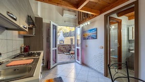 Una cocina moderna con estufa a gas, un lavamanos y un comedor con mesa y sillas.