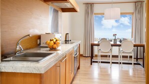 Una cocina moderna con isla integrada, pileta de acero inoxidable y comedor con mesa y sillas.