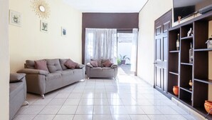 Una sala de estar con dos sofás grises, una mesa de centro y una estantería decorada con objetos.