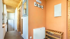 A hallway with wooden flooring, a white radiator, a wooden bench, and a welcome sign. - Ferienwohnung Mond mit Terrasse, Kamin und Garten - Ferienhaus Sonne, Mond und Sterne bei (Steffenshagen)