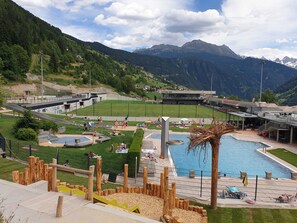 Ett semesterhotell med en swimmingpool, en lekplats för barn och utsikt över bergen.