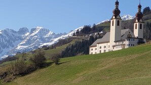 Una iglesia con dos torres y una montaña al fondo.