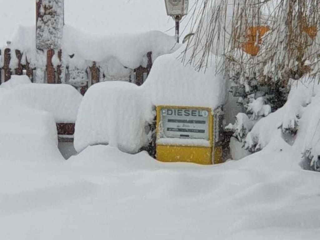 Une zone enneigée avec un panneau jaune, en partie enfoui sous la neige.