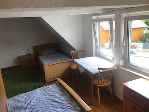 A small, compact room with a bed, a desk, and a window. - Ferienhaus Villa Alwine - Ferienhaus (Börßum)
