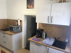 A compact kitchen with a microwave, toaster, coffee maker, and a sink. - Ferienhaus Villa Alwine - Ferienhaus (Börßum)
