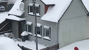 A residential building with a sloped roof, a satellite dish, and a visible garage door. - Ferienhaus Villa Alwine - Ferienhaus (Börßum)