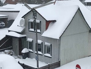 A residential building with a sloped roof, a satellite dish, and a visible garage door.