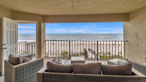 A balcony with wicker furniture and a view of the beach. - Wellness Retreat - Oceanfront condo w beach access (Ponte Vedra Beach)