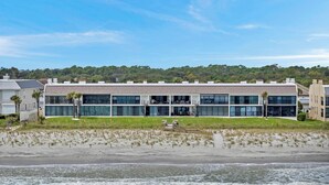 A modern beachfront hotel with a flat roof, large windows, and a grassy lawn. - Wellness Retreat - Oceanfront condo w beach access (Ponte Vedra Beach)