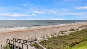 A beach with a wooden boardwalk leading to the shore, sandy dunes, and the ocean. - Wellness Retreat - Oceanfront condo w beach access (Ponte Vedra Beach)