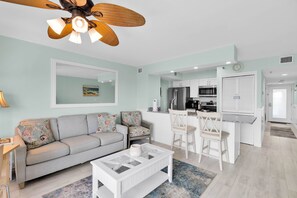 A living room with a sofa, coffee table, and a ceiling fan.