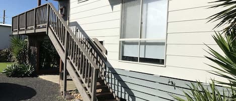 Une maison à deux étages avec un escalier en bois menant à un balcon.