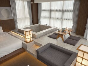 A modern hotel room with a large bathtub, a sofa, a dining table with tea sets, and a bed. - UH Suite The Myeongdong (Seoul)