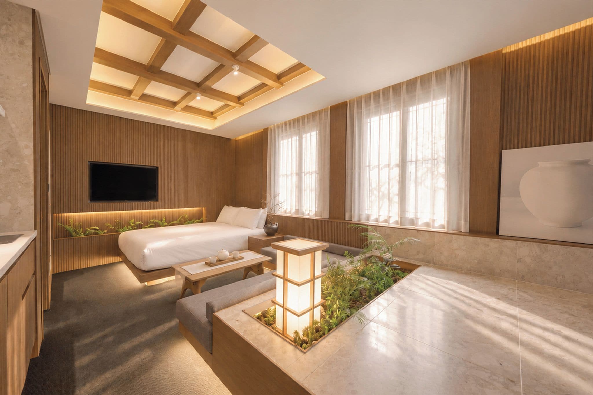 A modern bedroom with a bed, bedside table, TV, and a small indoor garden.