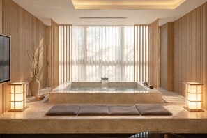 A modern spa room with a hot tub, seating area, and ambient lighting. - UH Suite The Myeongdong (Seoul)