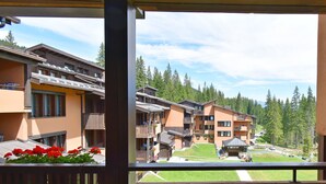 Vista de un hotel con varias construcciones, balcones y un área de césped verde.