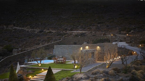 Edifici de pedra amb piscina, zones d'estar a l'aire lliure i un jardí ben cuidat.