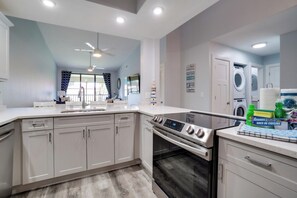 A modern kitchen with a built-in oven, a dishwasher, and a ceiling fan.