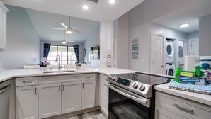 A modern kitchen with white cabinets, a built-in oven, and a dishwasher. - Near IMG - Shorewalk Unit 202 by SeaBreeze Vacation (Bradenton)