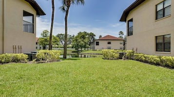 A courtyard with a water feature, palm trees, and a building with a red roof.