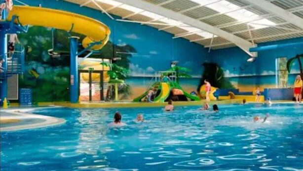 An indoor swimming pool with multiple water slides and a lifeguard tower. - 2-bed Caravan at Billing Aquadrome Northampton (Northampton)