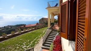A coastal building with a balcony overlooking the sea, a stone pathway, and a flower bed. - Apt Anna in Villa Laura near Ravello  (scala)