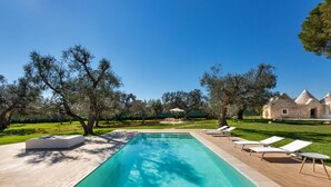 A rectangular swimming pool with a wooden deck and lounge chairs. - 2220 Trulli Biancapetra by Perle di Puglia (Francavilla Fontana)
