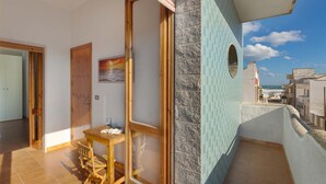 A balcony with a view of the sea, a wooden table, and a door leading to another room. - 2191 Appartamento Blue Dreams by Barbarhouse (Melendugno)