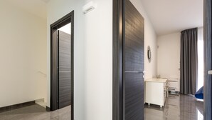 A modern interior with a hallway leading to a room with a desk and a chair. - 2178 Appartamento Negroamaro by Barbarhouse (Leverano)