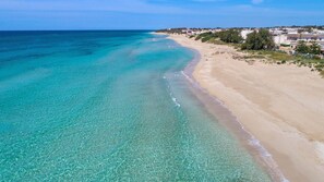 A coastal beach with clear turquoise waters and a sandy shore. - 2180 Villetta Degli Archi (Manduria)