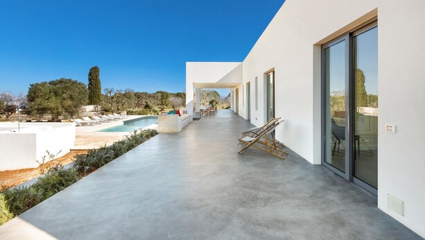 Eine moderne Terrassenanlage im Freien mit Pool, Sitzgelegenheit und freiem Blick auf die umliegende Landschaft.