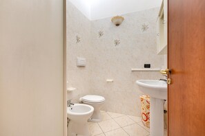 Ein Badezimmer mit Toilette, Bidet und Waschbecken.