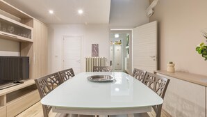 A modern dining area with a glass-top table, wooden chairs, and built-in shelving. - 2252 Suite 79 by Barbarhouse (Lecce)